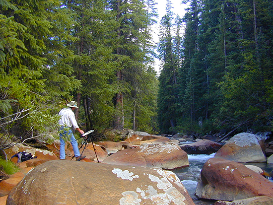 Photograph of John Hulsey painting in a Colorado stream